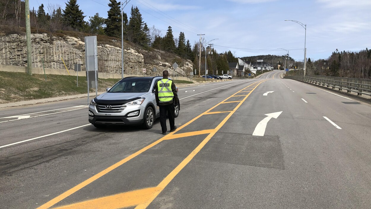 Un policier questionne un automobiliste.