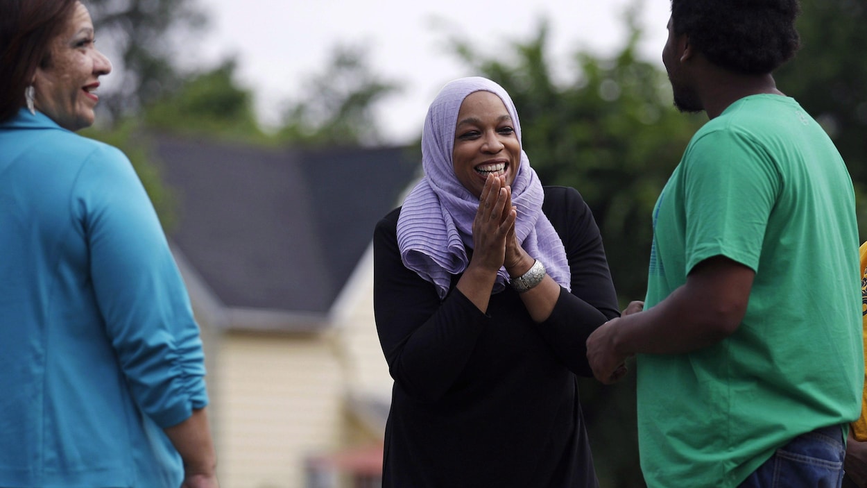 Tahirah Amatul-Wadud, entourée d'une femme et d'un homme. Tahirah Amatul-Wadud, entourée d'une femme et d'un homme.
