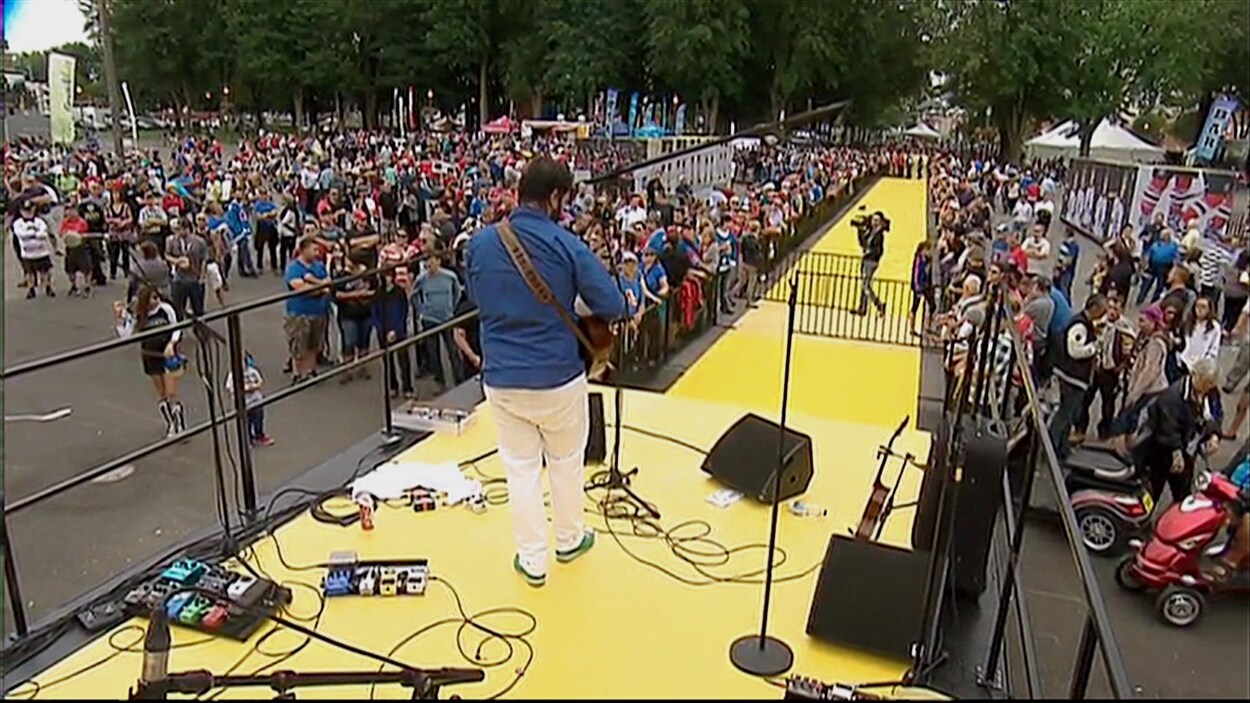 Pépé et sa guitare joue devant la foule. 