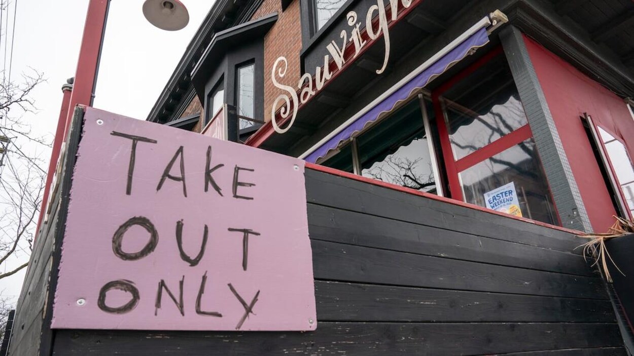 La façade d'un restaurant avec une grosse affiche rose.