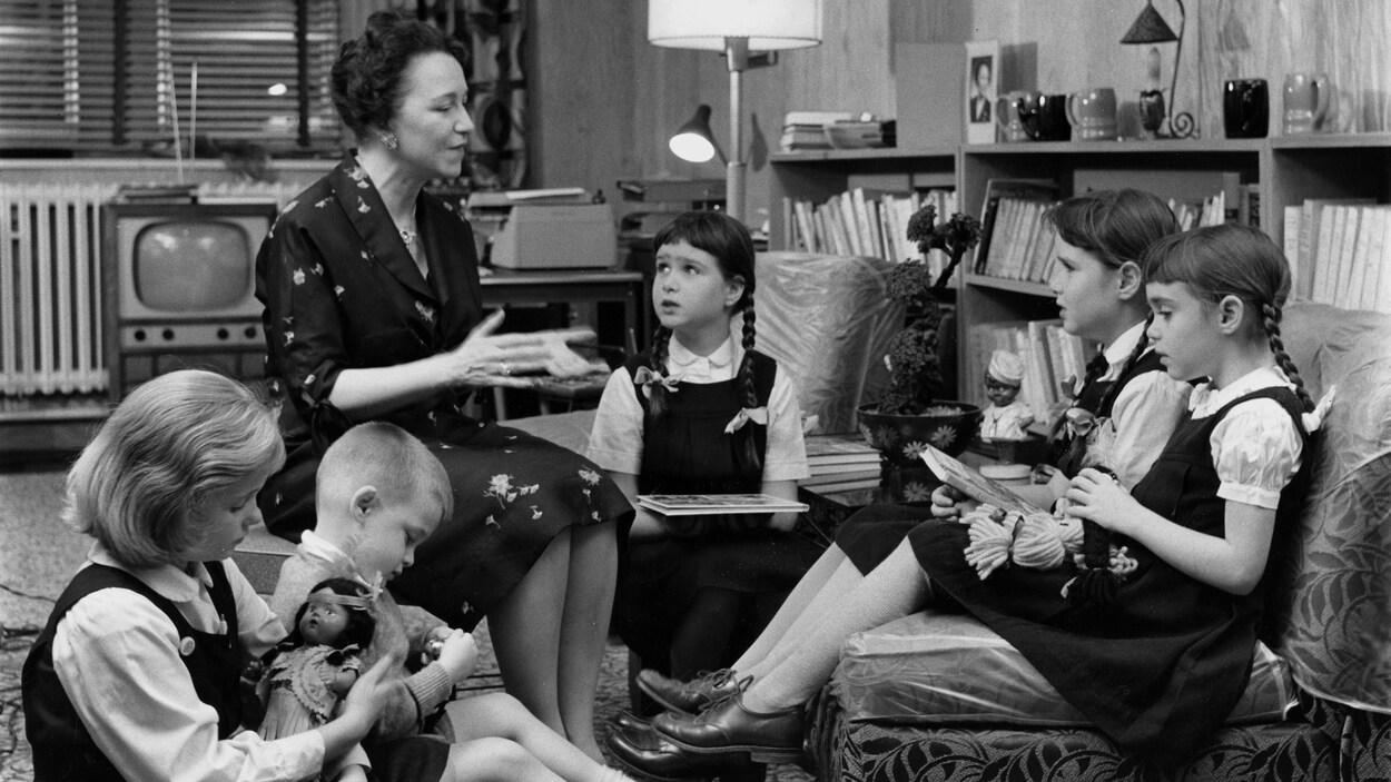 L'animatrice Lucille Desparois, assise, s'adresse à des enfants assis près d'elle dans un salon.