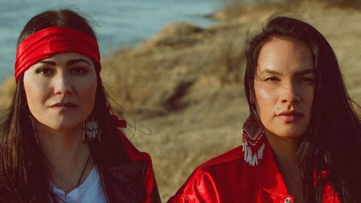 Les deux artistes côte-à-côte près d'une rivière.