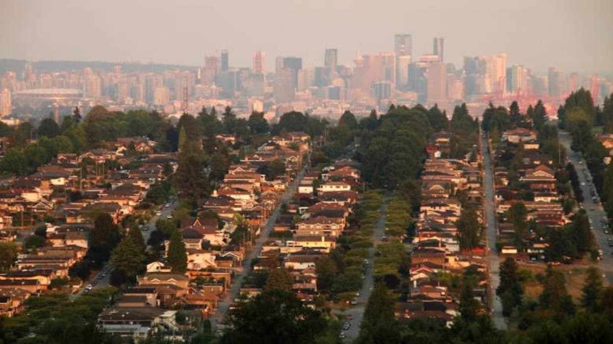 Photo très large sur le centre-ville de Vancouver avec des rangées de maisons en avant-plan.