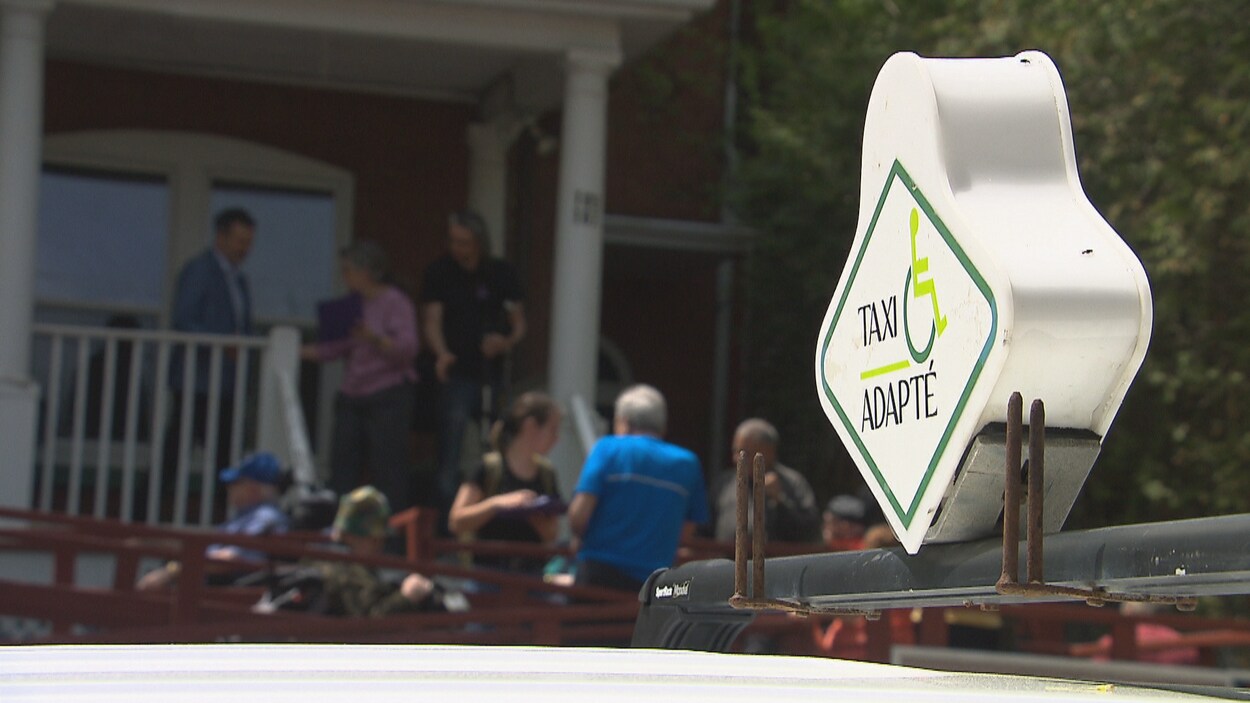 Le symbole lumineux sur le toit d'un taxi sur lequel il est inscrit « taxi adapté».