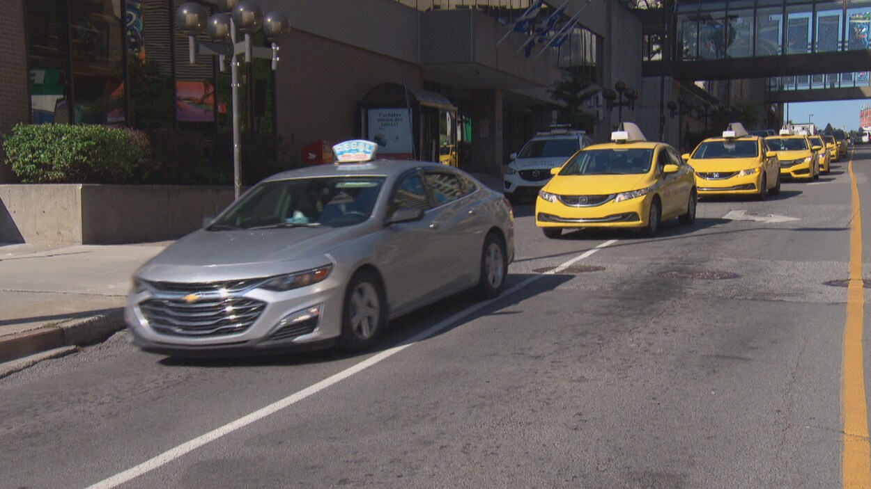 Des taxis se suivent et bloquent la circulation.