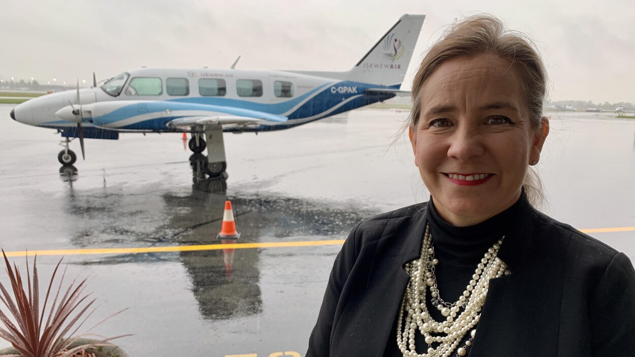 Teara Fraser devant un avion de sa compagnie.