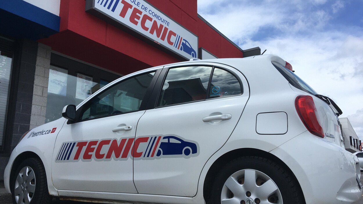 Une voiture tecnic stationnée devant l'école de conduite.