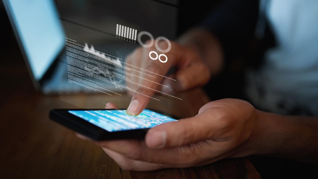 Un gros plan sur les mains d'une personne en train d'utiliser un téléphone cellulaire.