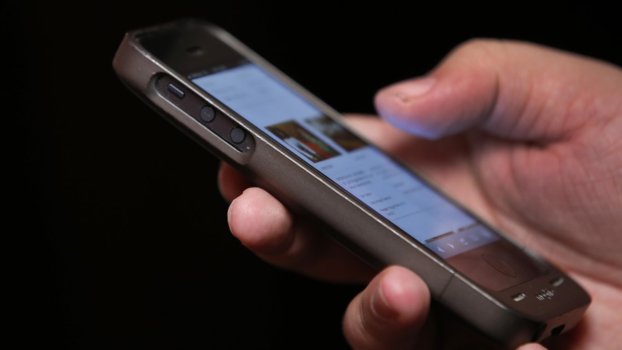 Une main tient un téléphone intelligent. Une main tient un téléphone intelligent.