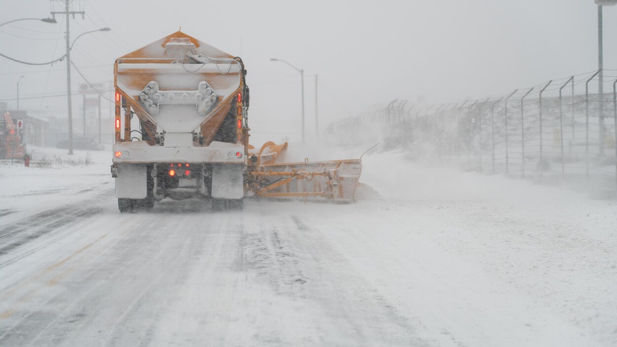 Un camion déneige une route.