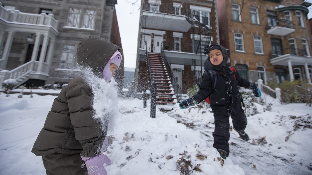Deux enfants s'amusent dans la neige.