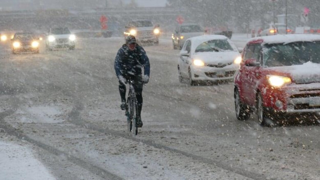 Un cycliste pédale sous la neige à Winnipeg.