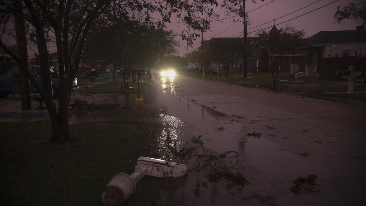 Une rue de la ville d'Arabi, en Louisiane, où l'ont peut voir que tous les lampadaires sont éteints et sur la route, des débris.