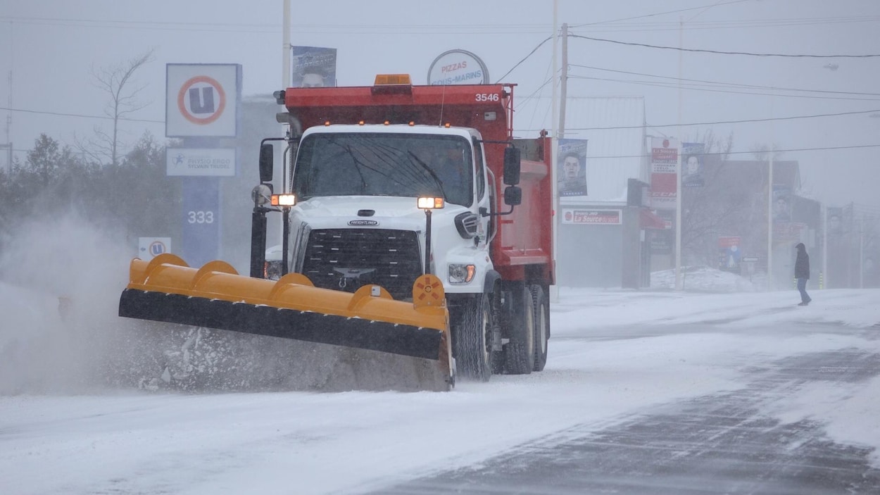 Un camion gratte la neige sur une rue de Rimouski.