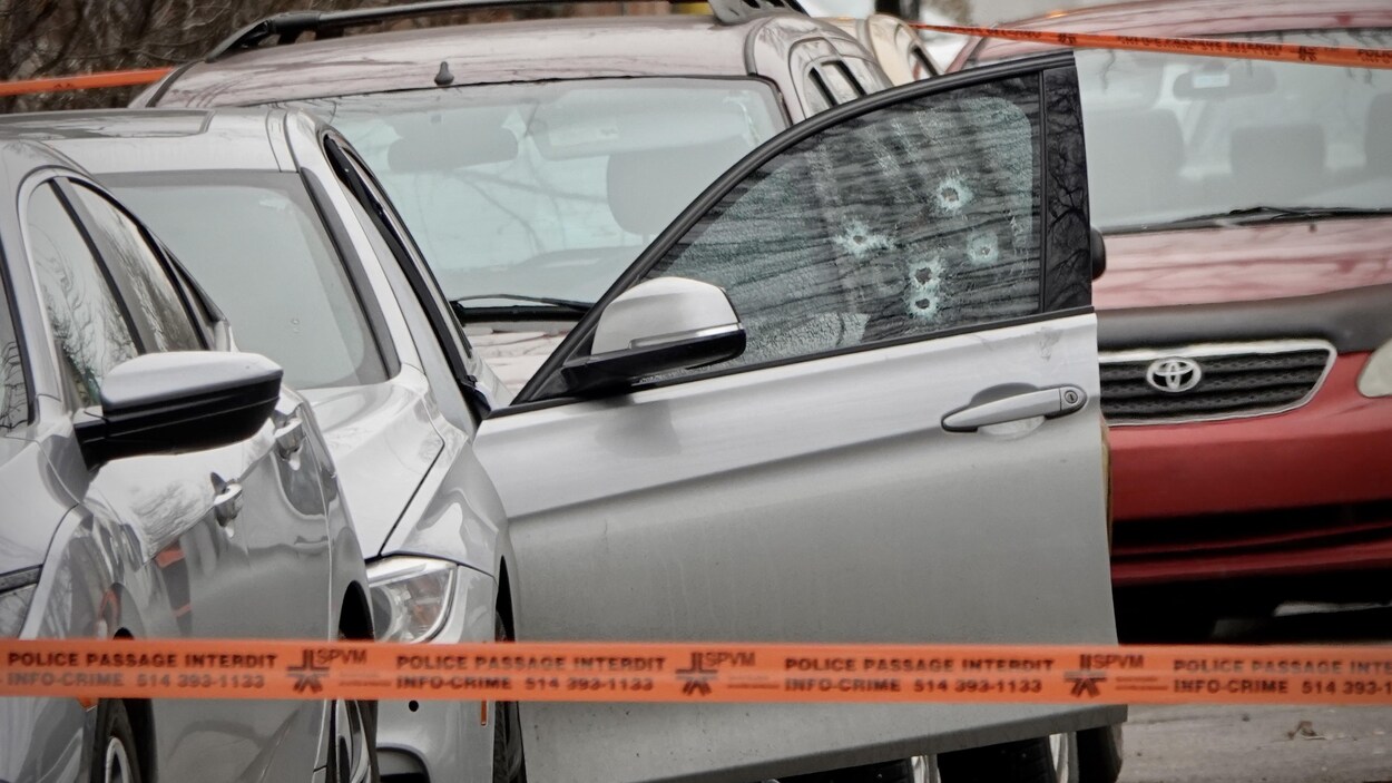 Une voiture dont la fenêtre côté conducteur a été traversée par des balles d'arme à feu.