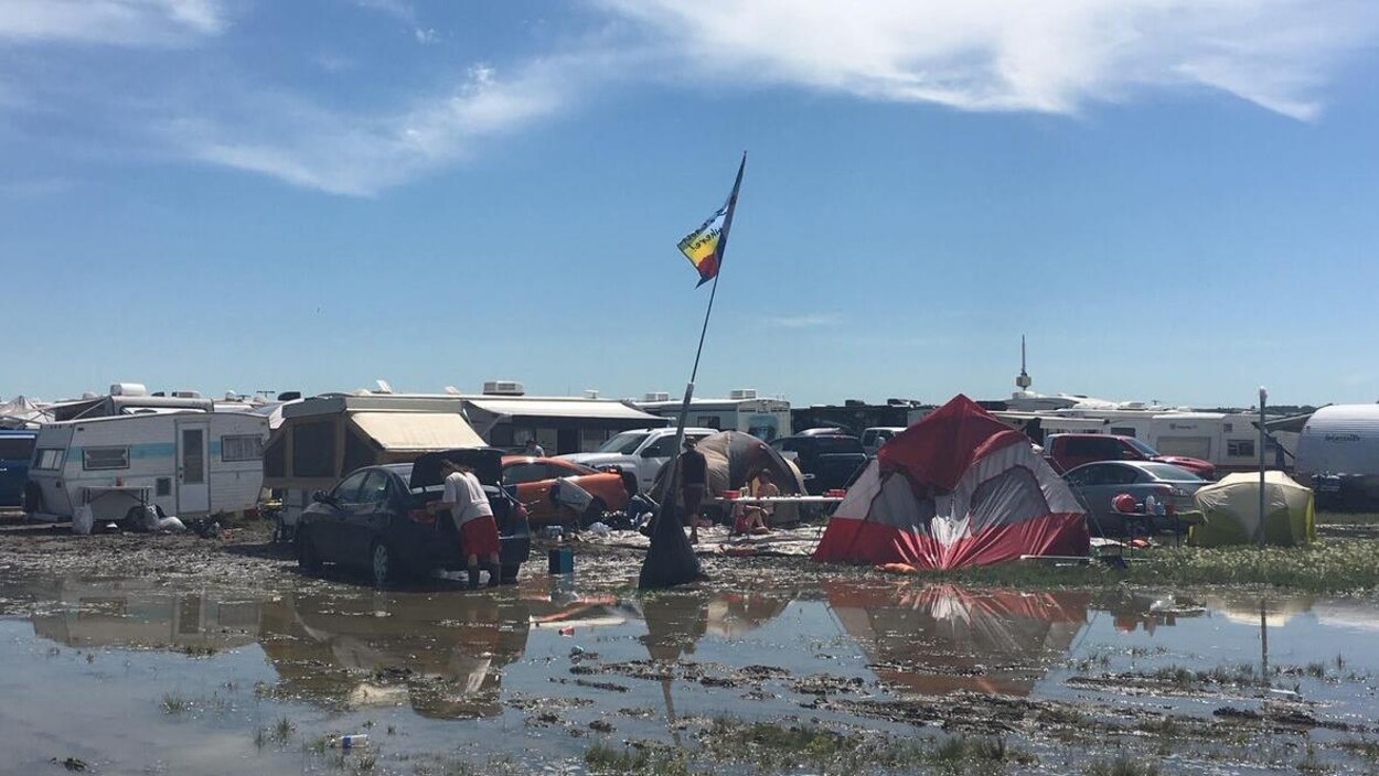 Des tentes et caravanes sur un terrain gorgé d'eau