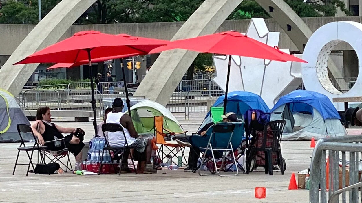 Quatre personnes assises en cercle sur des chaises de camping.
