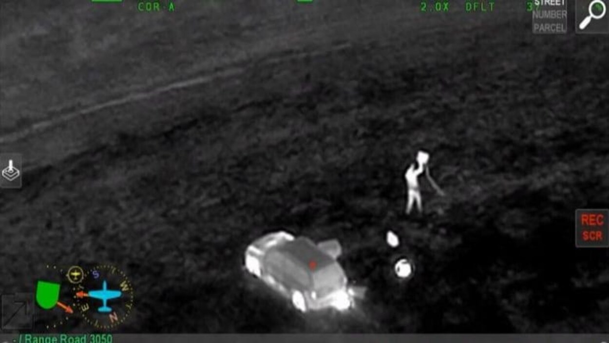 Image infrarouge où l'on aperçoit Terrance Morin dans un champ, près du véhicule qu'il a volé.