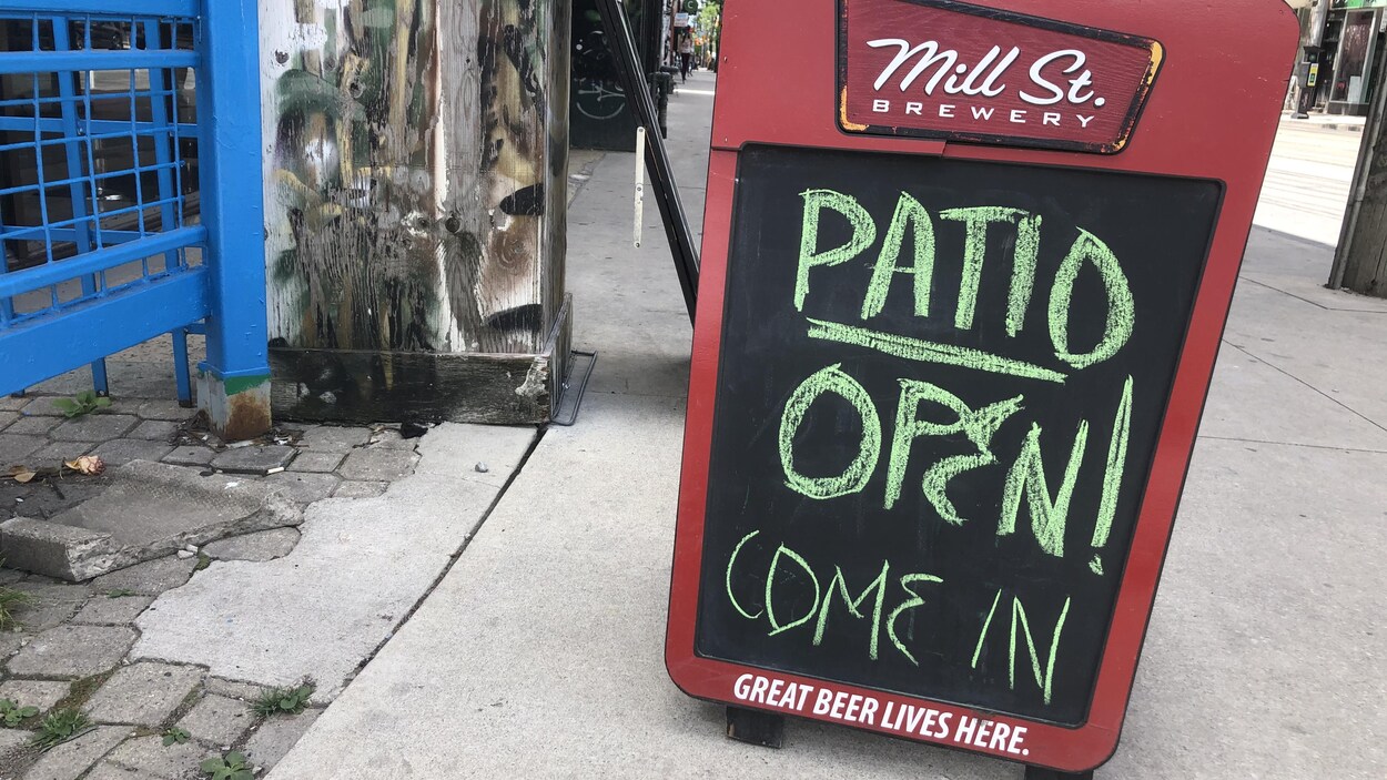 Une enseigne sut le trottoir indiquant que la terrasse du Java Cafe est ouverte.