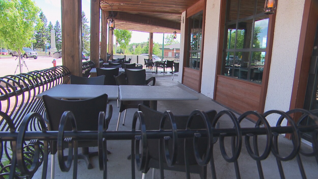Une terrasse extérieure avec des tables et des chaises sans clients.