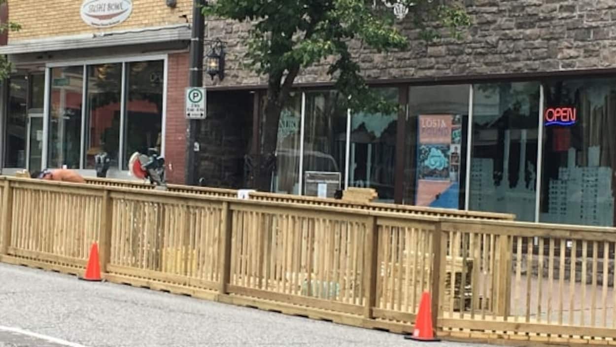 Une terrasse et un trottoir en bois devant un restaurant.