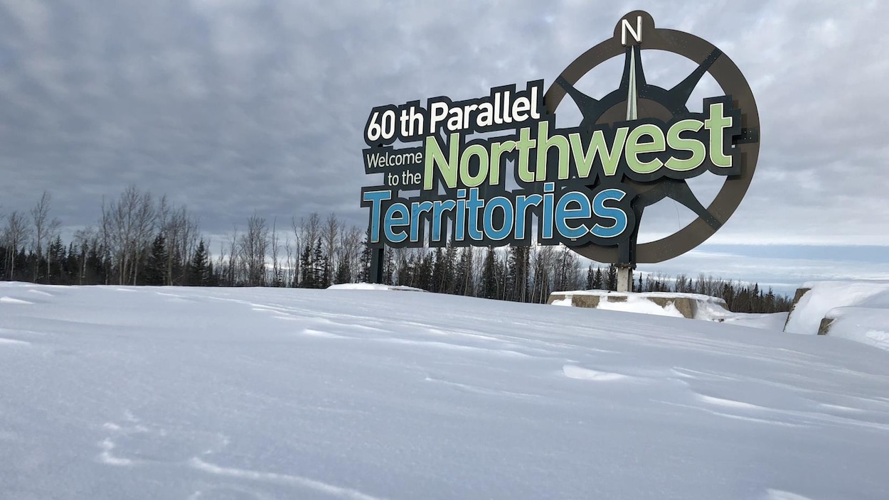 Enseigne des Territoires du Nord-Ouest dans un paysage d'hiver.
