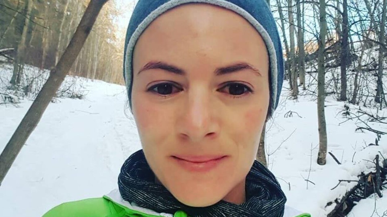 Une femme, qui porte un bonnet, se tient debout au milieu des bois. Une femme, qui porte un bonnet, se tient debout au milieu des bois.