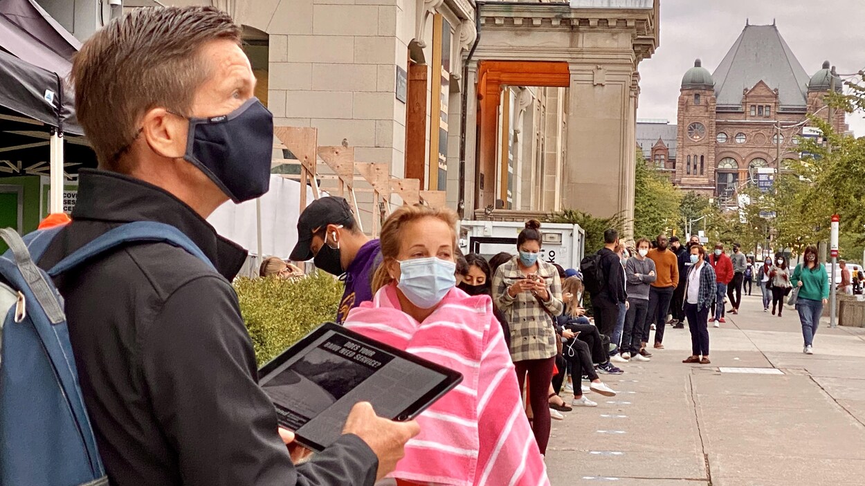Des gens attendent en ligne pour subir un test de dépistage à Toronto.