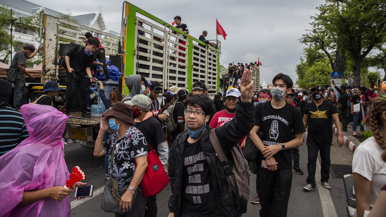 Les manifestants descendent du derrière de grandes camionnettes.