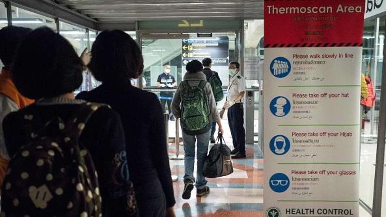 Des passagers en provenance de la Chine se soumettent à une thermographie.
