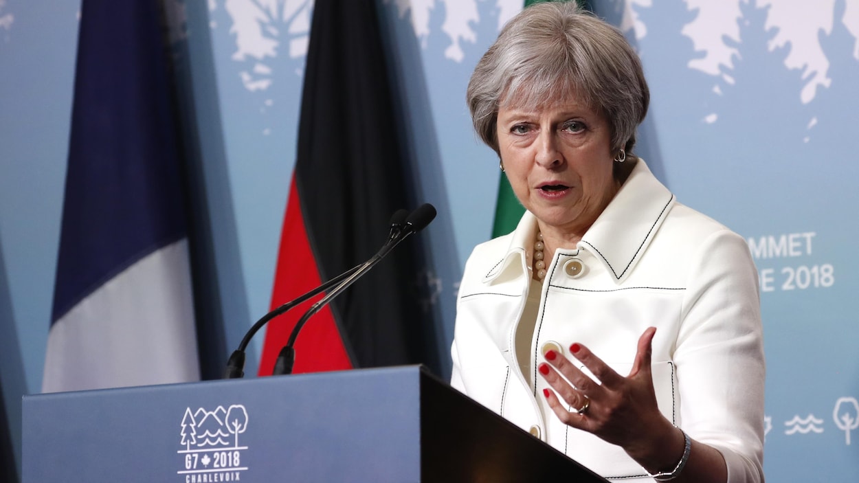 La première ministre britannique Theresa May lors du Sommet du G7 tenu à La Malbaie prend la parole derrière une tribune.