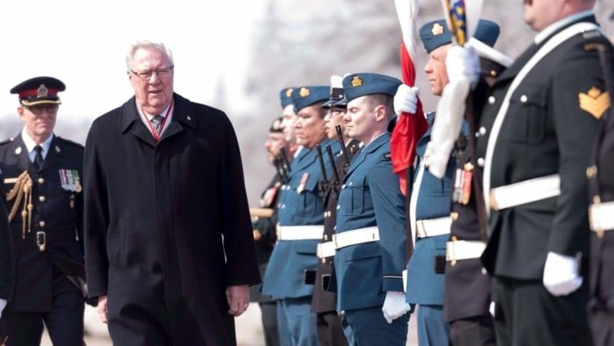 Thomas Molloy passe devant des officiers.