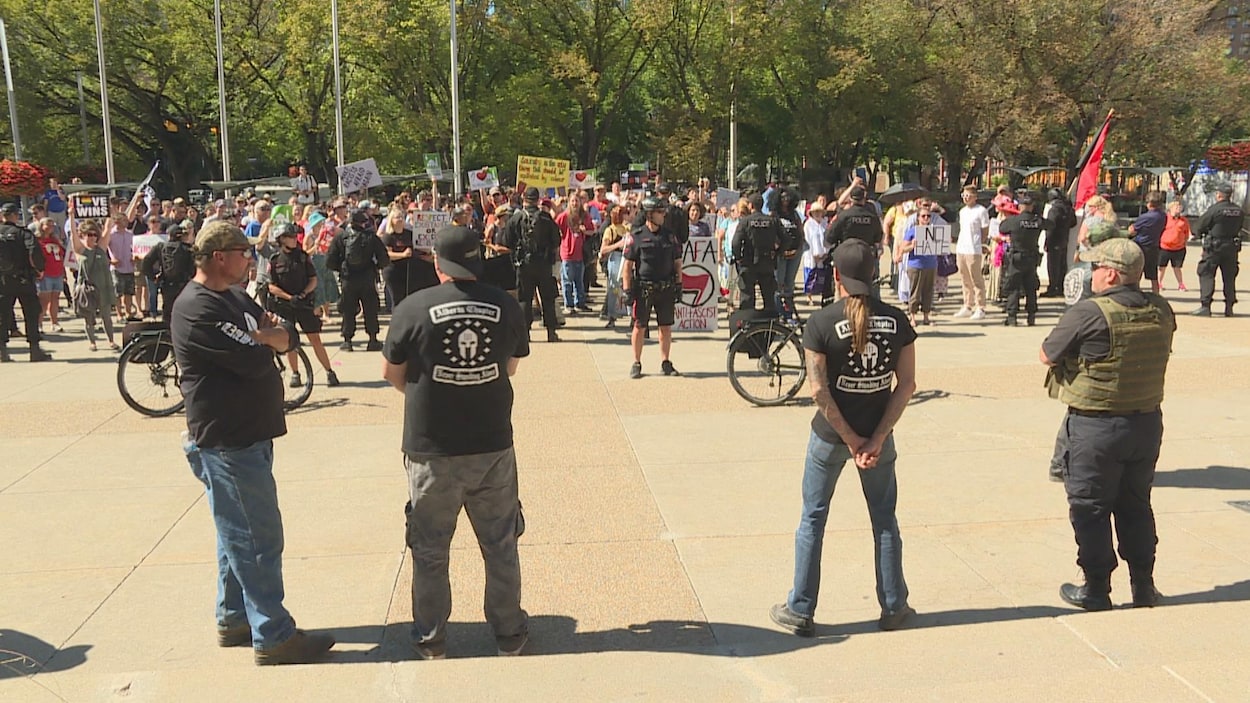 4 hommes debout devant la police et les manifestants antifascistes 4 hommes debout devant la police et les manifestants antifascistes