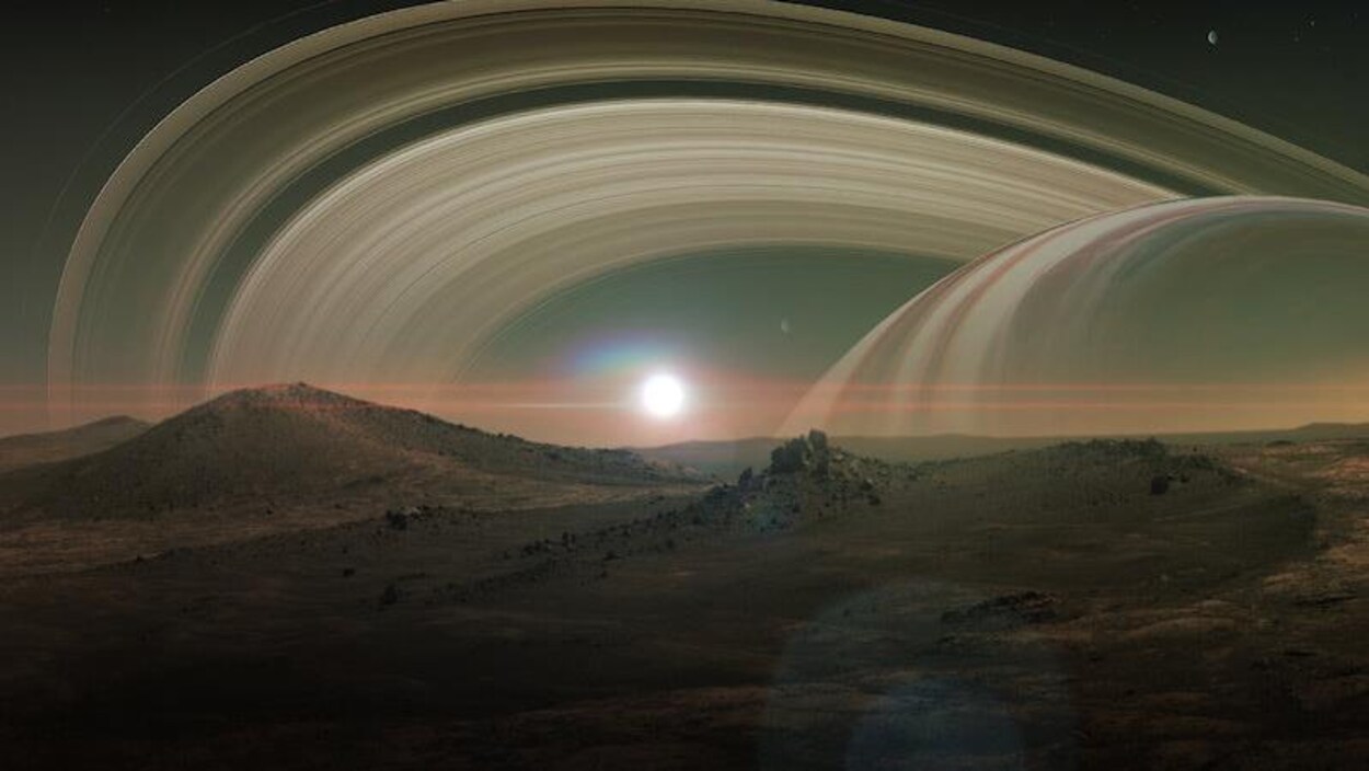 Impression artistique de la surface de Titan, avec en arrière plan les anneaux de Saturne.