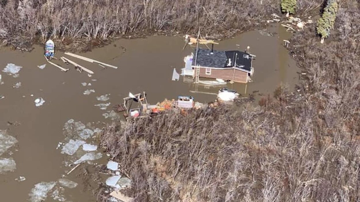 Vue aérienne d'un chalet entouré d'eau.