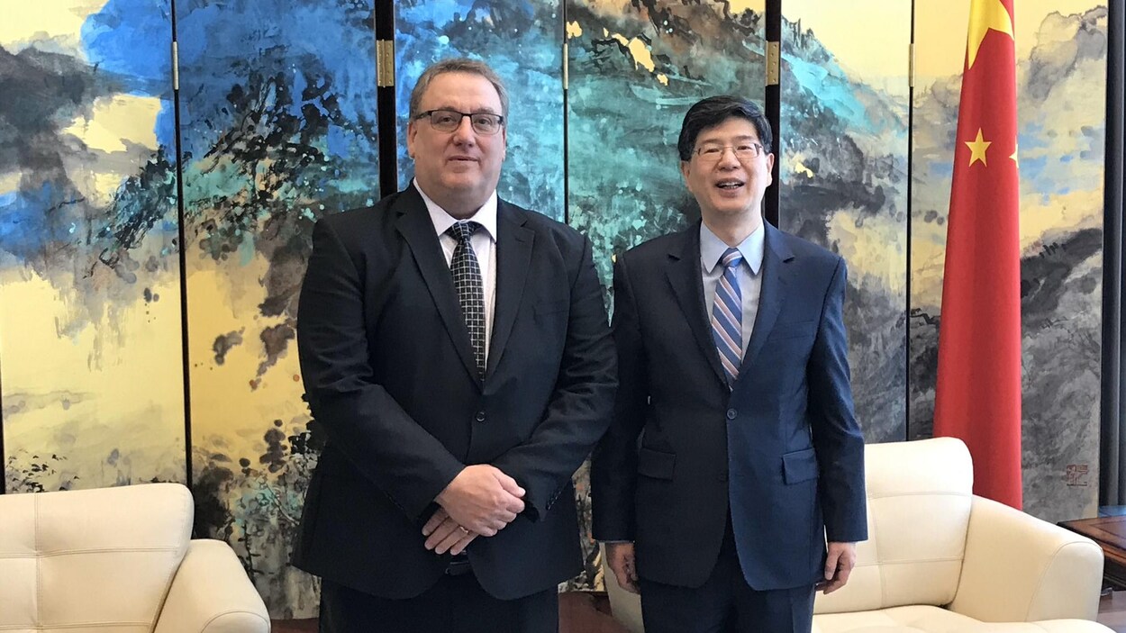 Deux hommes avec à leur gauche le drapeau chinois.