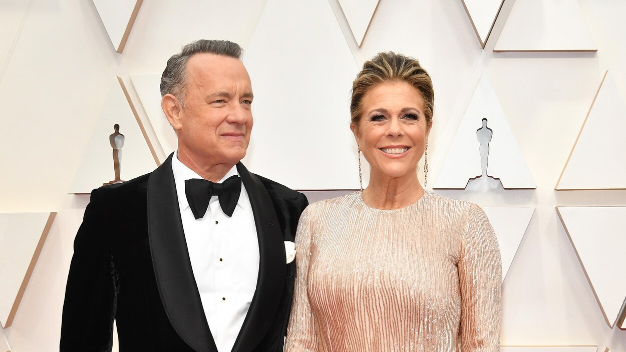 Tom Hanks et sa femme sourient. Les deux sont habillés en tenue de gala.