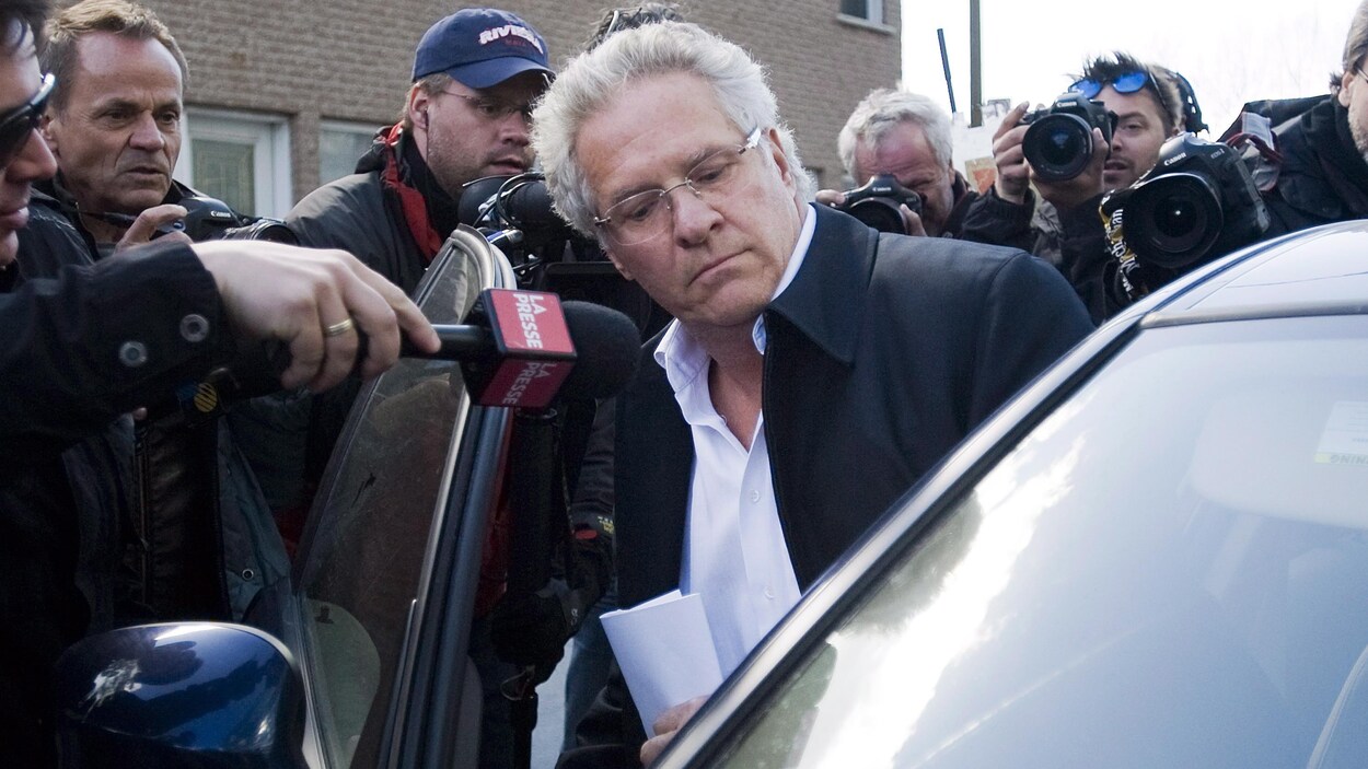 Tony Accurso entre dans une voiture côté passager, entouré de photographes de presse. Tony Accurso entre dans une voiture côté passager, entouré de photographes de presse.