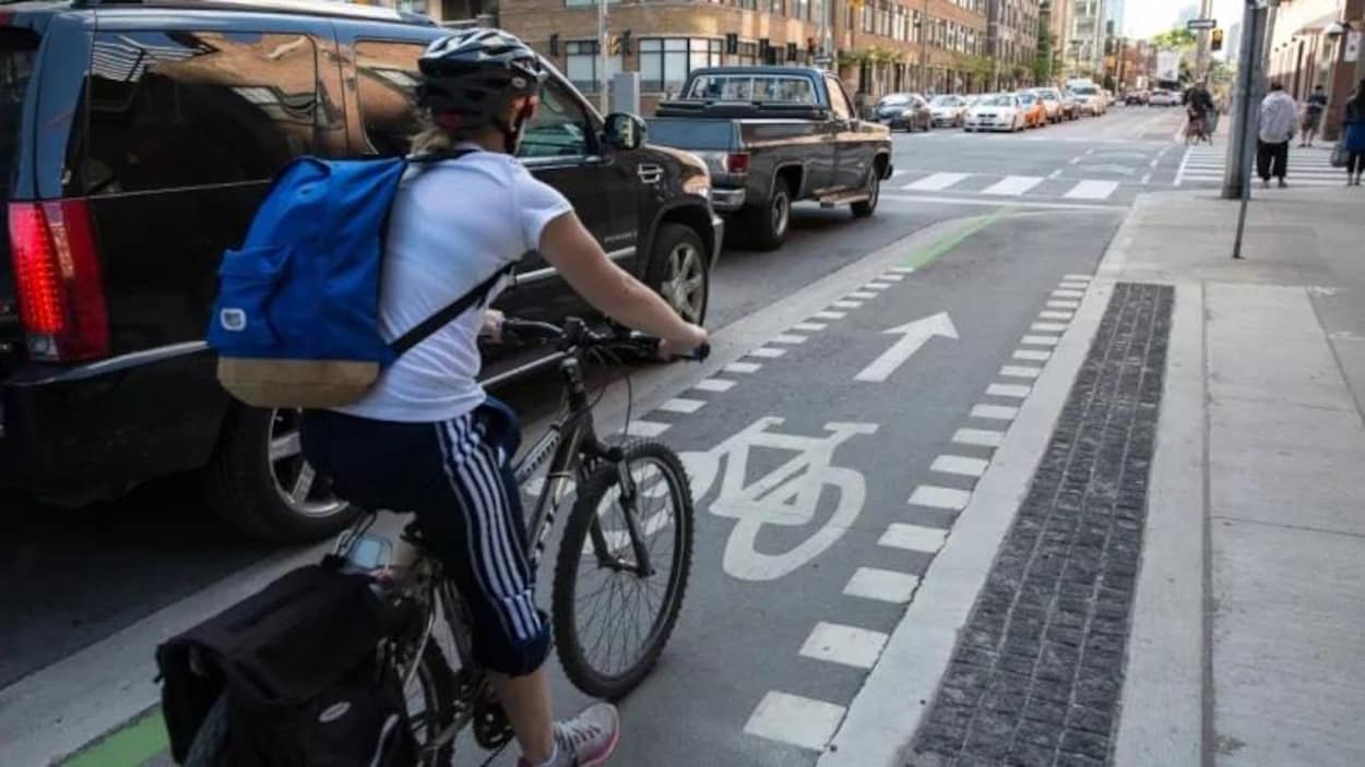 Une dame en vélo dans une piste cyclable
