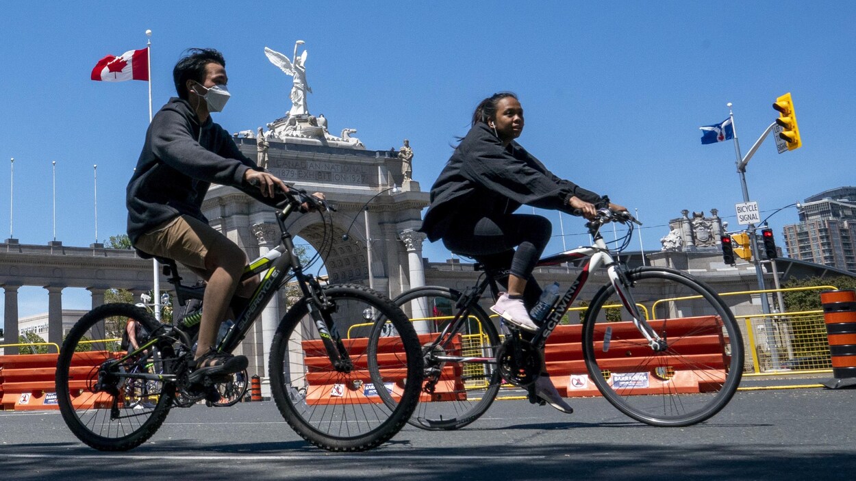 Des Torontois profitent de la fermeture du boulevard Lakeshore à la circulation automobile pour faire du vélo.