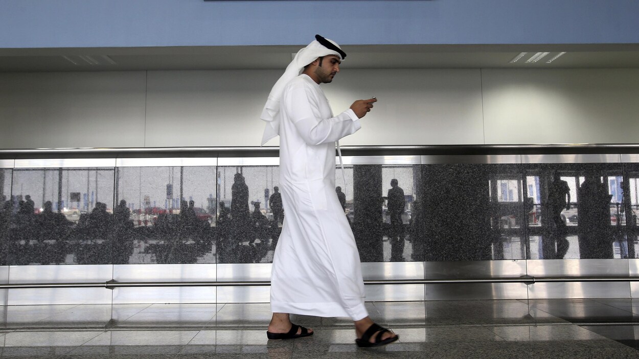 Un homme regarde son téléphone aux Émirats arabes unis.