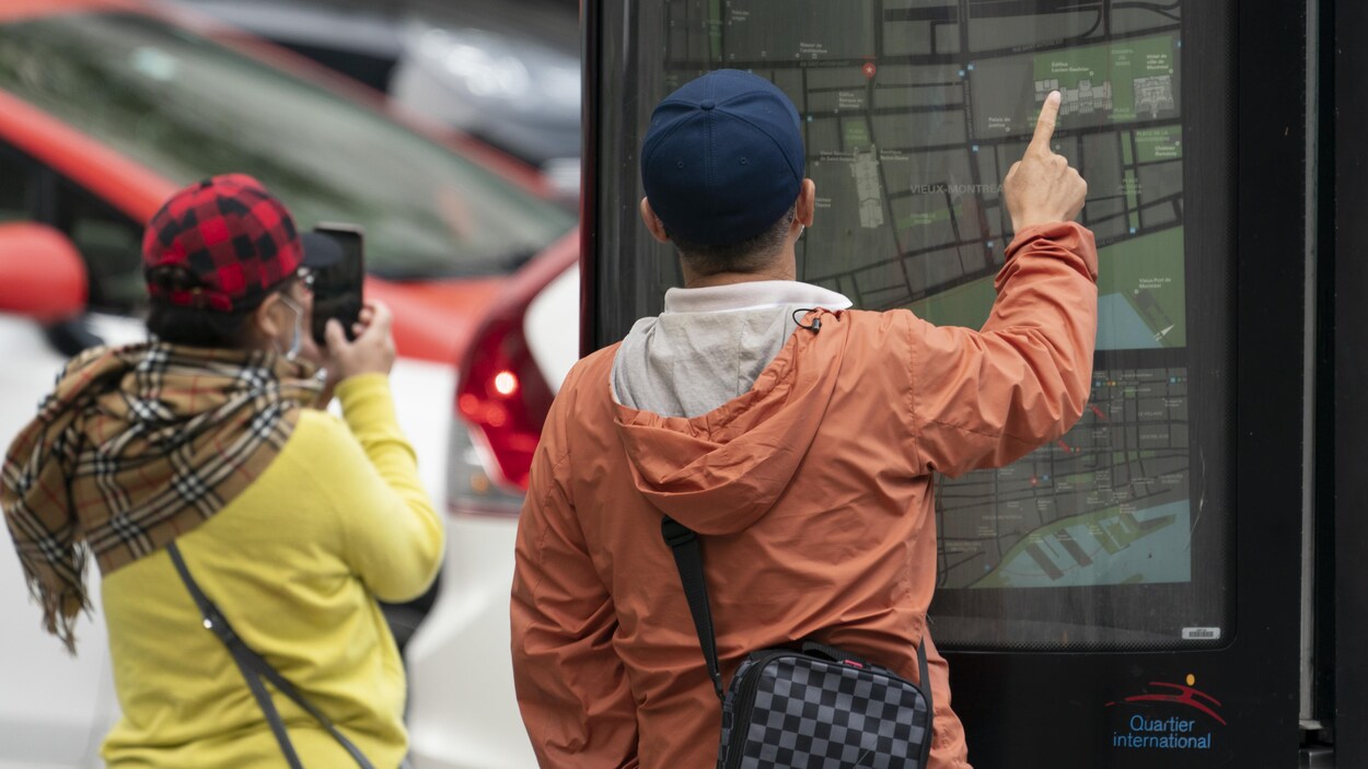 Deux personnes de dos regardent une carte du centre-ville de Montréal.