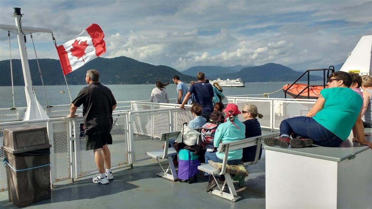 Des passagers sont sur le pont d'un traversier qui se dirige vers l'île Bowen.