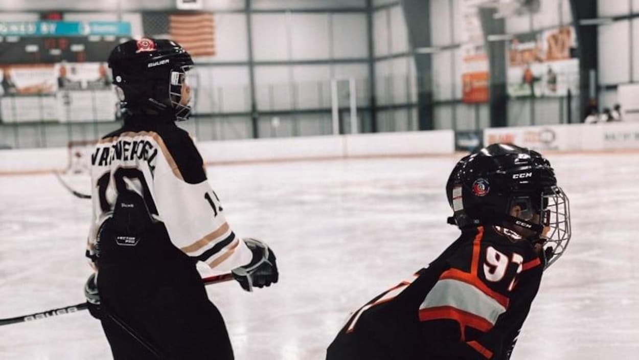 Deux joueurs de hockey sur la patinoire.