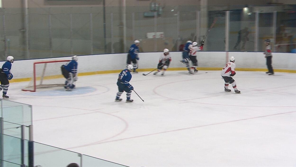 Des jeunes jouent au hockey dans un aréna