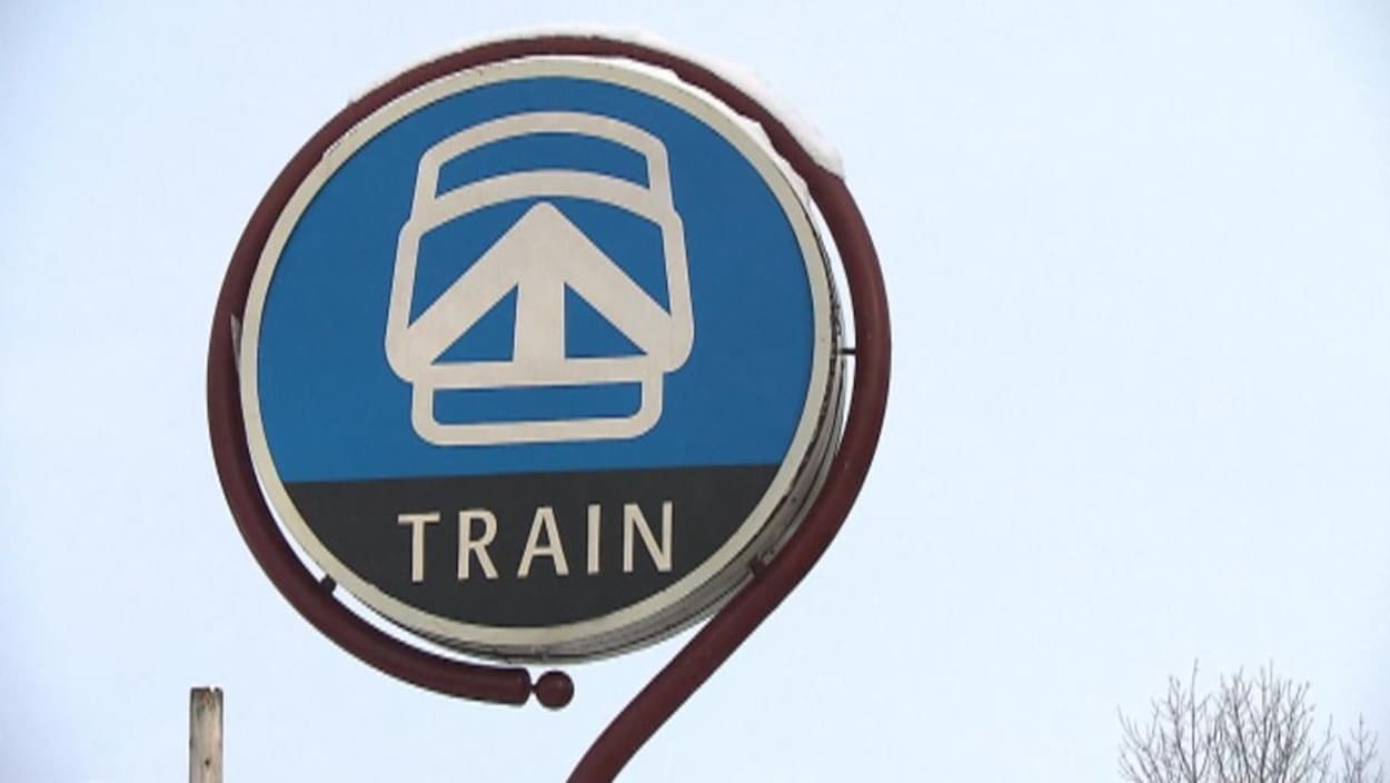 Une affiche de train de banlieue, avec la forme d'une locomotive et une flèche