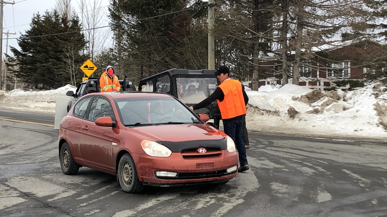Des gens qui distribuent des tracts à un automobiliste