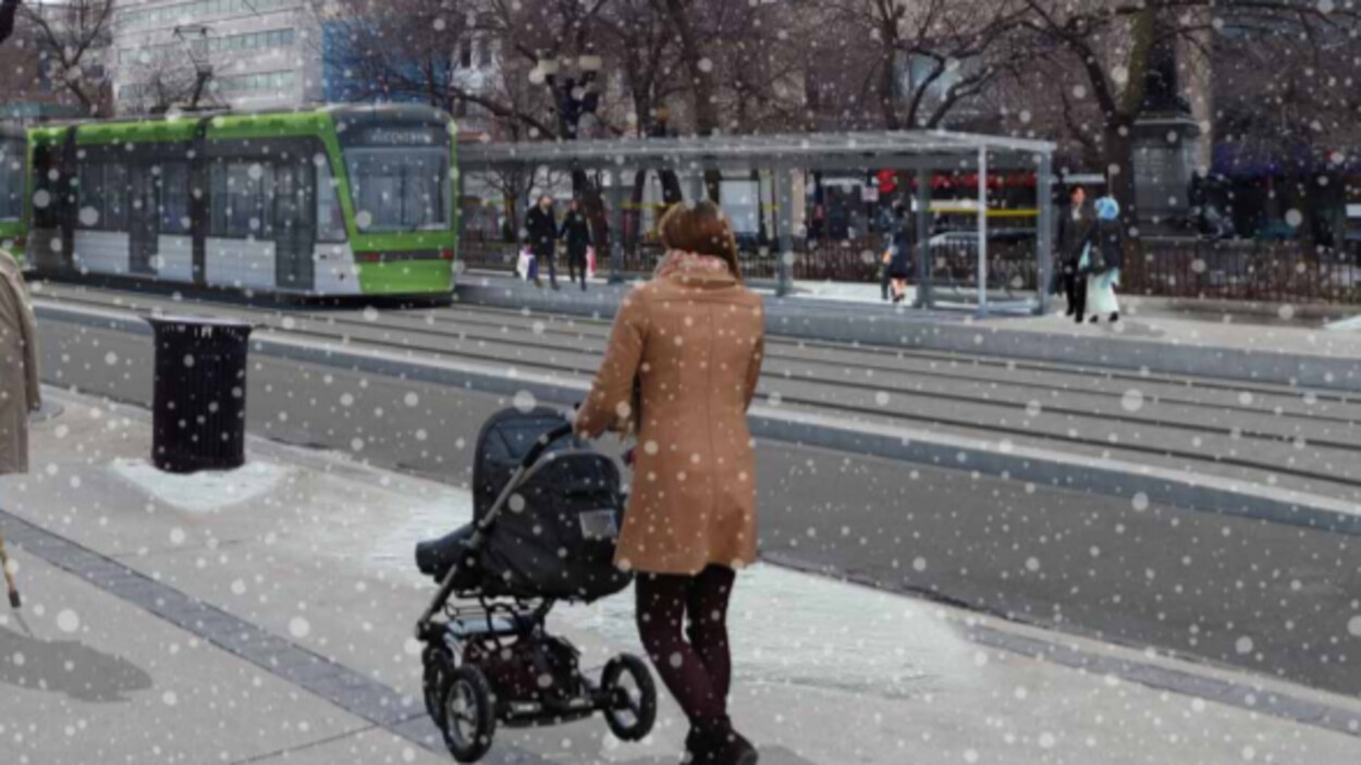 Photo d'une mère qui pousse son bébé en poussette alors qu'arrive un train léger.