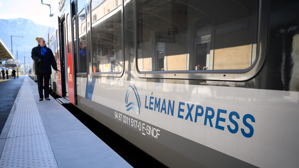 Vue latérale d'un train du Léman Express, arrêté dans une gare.