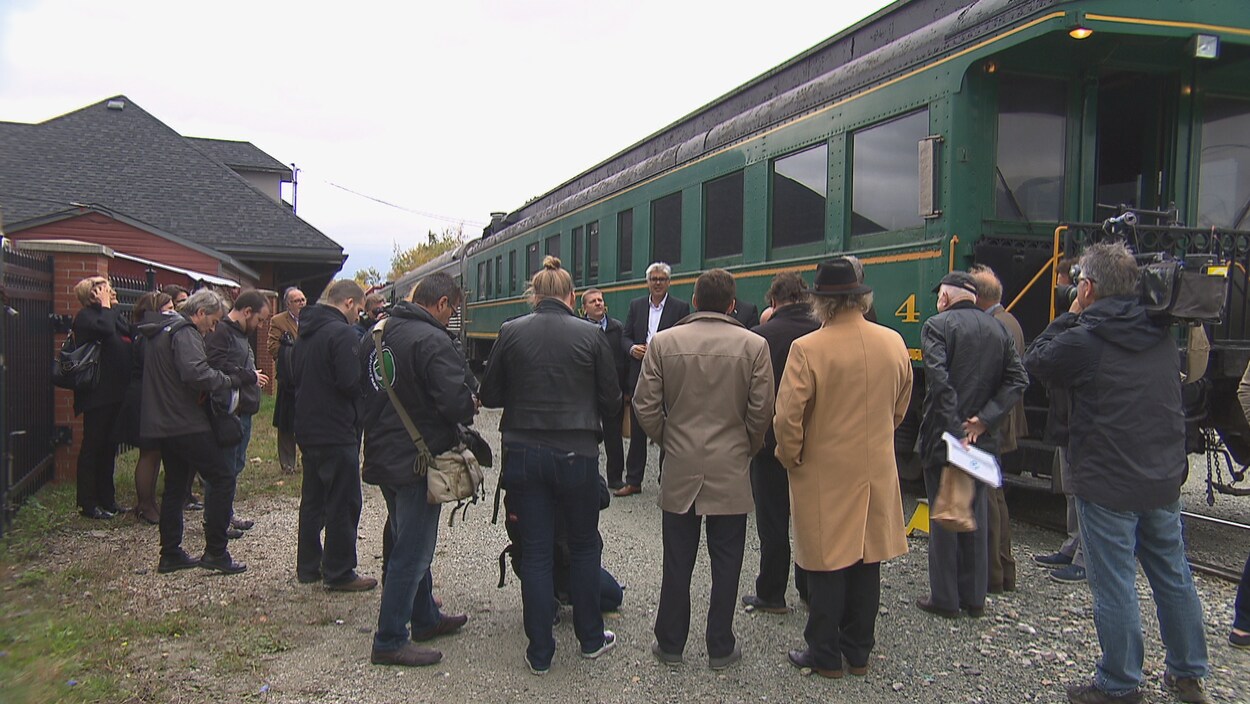 Plusieurs journalistes et des représentants de municipalités écoutent le promoteur du projet de train de passagers entre Montréal et Sherbrooke, François Rebello, au centre de l'image Plusieurs journalistes et des représentants de municipalités écoutent le promoteur du projet de train de passagers entre Montréal et Sherbrooke, François Rebello, au centre de l'image